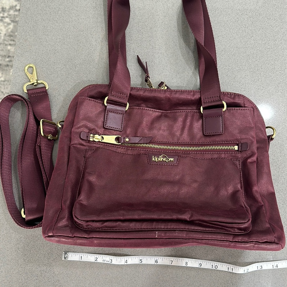 Kipling Metallic Burgandy handbag with adjustable detachable crossbody strap.